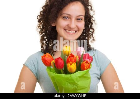 Junge natürliche Frau mit lockigen Haaren, die einen Blumenstrauß mit bunten Tulpen hält, isoliert auf weißem Hintergrund. Muttertag, Valentinstag, Osterkonzept. Stockfoto