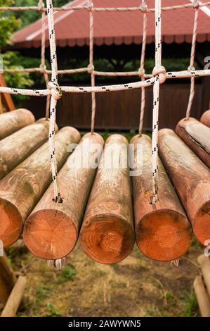 Vertikale Aufnahme einer schwingenden Brücke aus Holz in Der Park Stockfoto