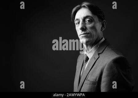 Reifen gutaussehenden italienischen Geschäftsmann gegen grauer Hintergrund Stockfoto