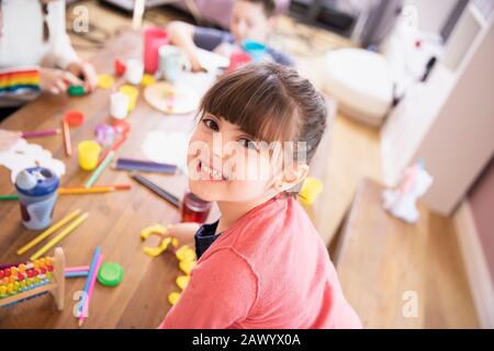 Portrait fröhliches begeistertes Mädchen, das mit Spielzeug am Tisch spielt Stockfoto