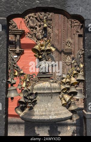 Viele goldene buddhistische Glocken mit Wünschen in einem Tempel von Patan in der Nähe von Kathmandu in Nepal Stockfoto