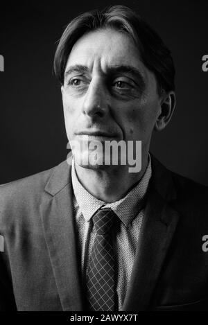 Reifen gutaussehenden italienischen Geschäftsmann gegen grauer Hintergrund Stockfoto