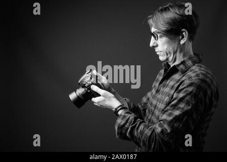 Reifer italienischer Hippie-Mann vor grauem Hintergrund Stockfoto