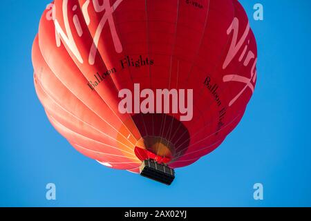 Die Passagiere schauen direkt von unten aus dem Korb eines "Virgin"-Heißluftballons. Stockfoto