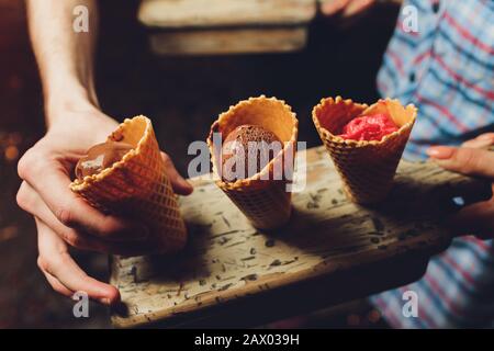 Wafer mit Schokoladenfüllung auf einem Holzteller Waffelhörner mit Hüttenkäse werden mit Schokolade bestreut Stockfoto