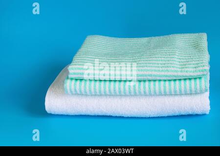 Weiches Frotteehandtuch aus Baumwolle auf blauem Hintergrund. Badetuch. Persönliche Hygieneartikel. Stockfoto