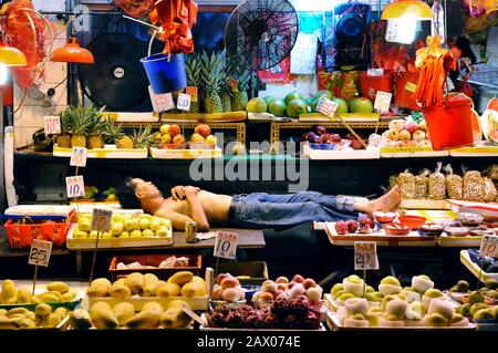 Der Obsthändler ruht sich an seinem Stand in Bowrington Road Market, Wanchai, Hongkong aus Stockfoto