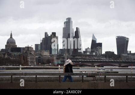 Die Menschen spazieren durch starke Winde über die Waterloo Bridge in London, sagte das Met Office, dass "ein Zauber sehr starker Winde" mit Böen von 60 bis 70 mph am Montag über Südengland erwartet wird, was zu Verzögerungen im Straßen-, Schienen-, Luft- und Fährverkehr führt. Stockfoto