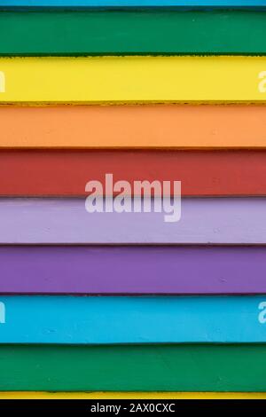 Mehrfarbige Regenbogenbemalte Holzwetterplatten, vertikaler bunter Texturhintergrund Stockfoto