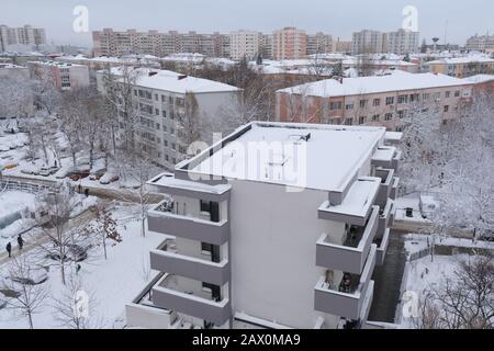 Bukarest, Rumänien - 6. Februar 2020: Winterszene in einem Wohngebiet mit neuen und alten Wohnblockgebäuden, mit schneebedeckten Dächern, in Buch Stockfoto