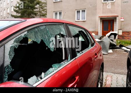 Pilsen, Tschechien. Februar 2020. Am Montag, 10. Februar 2020, in Pilsen, Tschechien, sind ein beschädigtes Auto und ein gestürztes Dach (auf dem Hintergrund) eines Apartmentgebäudes nach dem Sturm Ciara (Sabine) zu sehen. Kredit: Miroslav Chaloupka/CTK Foto/Alamy Live News Stockfoto
