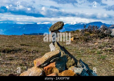 Ein Kairn (von Menschen angefertigter Stapel/Steinstapel) mit den französischen Alpen Bergen im Hintergrund Stockfoto