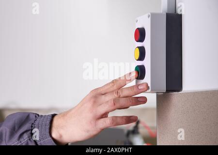 Arbeiter, der eine Maschine in einer Fabrik betreibt Stockfoto