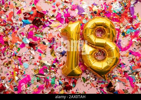 Nummer 18 Goldgeburtstag Ballon auf einem Konfetti-Glitzer-Hintergrund Stockfoto