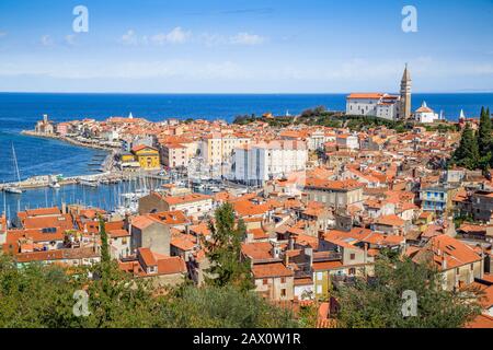 Wunderschöner Blick auf das historische Stadtzentrum von Piran mit berühmter Kirche des Heiligen Georg und dem Tatini-Platz an einem sonnigen Tag, Istrien, Slowenien Stockfoto