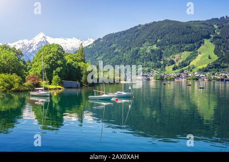 Panoramasicht auf den idyllischen Zeller See mit Altstadt von Zell am See und schneebedeckter alpiner Bergkuppe Kitzsteinhorn, Salzburger Land, Österreich Stockfoto