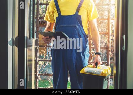 Dienstleistungen für Handwerker - Reparaturwerkstatt mit Werkzeugkasten, der am Hauseingang steht Stockfoto