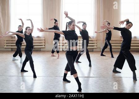 Horizontaler Schuss des zeitgenössischen Tanzteams, das neue Bewegungen in ihren Probebewegungen erlernt Stockfoto