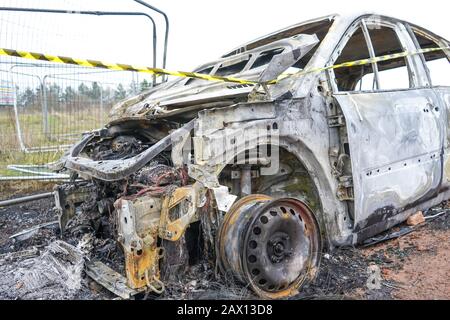 Nahaufnahme des vereinzelten, ausgebrannten Renault Scenic Autos, das auf britischer Brachfläche aufgegeben wurde. Vandalismus und Motorkriminalität in Großbritannien. Polizei bekannt. Stockfoto