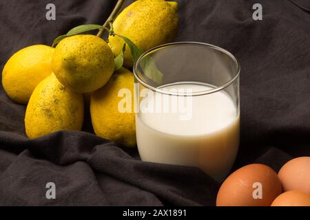 Frisch gemolkte weiße Milch aus der Kuh und gelbe Zitronen mit einem sauren Geschmack aus der Familie der Zitrusfrüchte. Zwei Zutaten, die immer noch im Gegensatz stehen, sind weit verbreitet Stockfoto