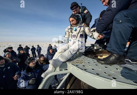 Roskosmos Kosmonaut Alexander Skvortsov wird nur wenige Minuten nach seiner Landung, ESA-Astronaut Luca Parmitano und NASA-Astronautin Christina Koch, an Bord des russischen Raumschiffs Sojus MS-13 in einem abgelegenen Gebiet am 6. Februar 2020 in der Nähe der Stadt Zhezkazgan, Kasachstan, geholfen. Stockfoto