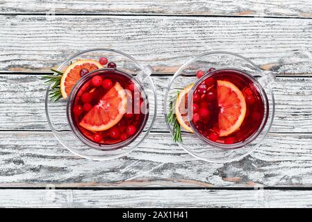 Heißes Getränk aus Preiselbeere und Orange in Tassen. Auf weißem Holzhintergrund. Draufsicht. Freier Speicherplatz für Ihren Text. Stockfoto