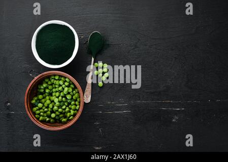 Spirulina-Pulver und Tabletten. Superfood - Draufsicht. Freier Speicherplatz. Stockfoto