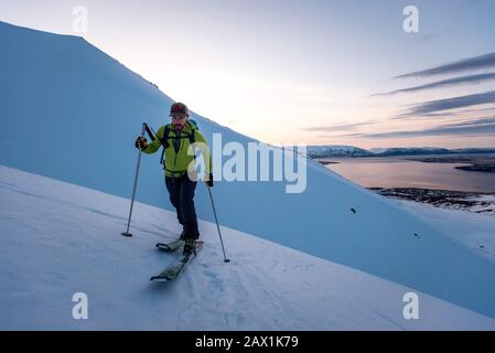 Mann beim Skifahren in Island bei Sonnenaufgang Stockfoto