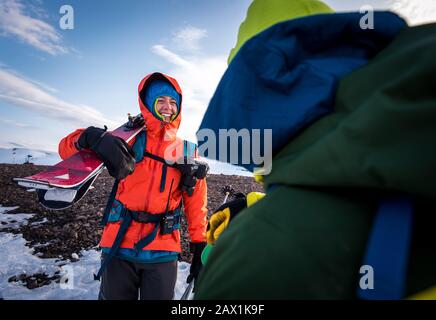 Frau im Gespräch mit Mann mit Skiern in Island Stockfoto