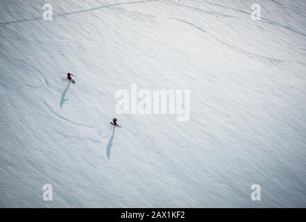 Zwei Männer, die auf Schnee in Island aus dem Winkel oben fahren Stockfoto