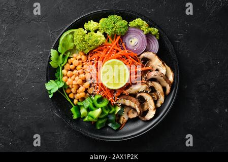 Veganes Frühstück in einer Schüssel mit Pilzen, türkischer Erbse und Gemüse. Draufsicht. Freier Speicherplatz für Ihren Text. Stockfoto