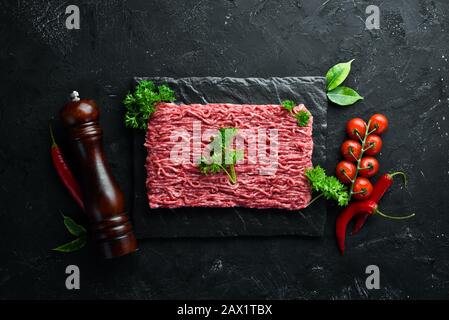 Hackfleisch. Fleisch und Gewürze auf dem alten Tisch. Draufsicht. Freier Speicherplatz für Ihren Text. Stockfoto