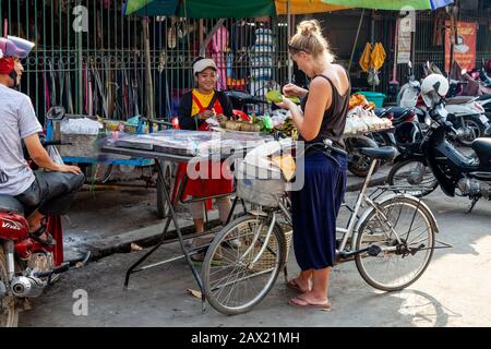 Ein weiblicher Reisender Kauft Street Food Von A Stall, Battambang, Kambodscha. Stockfoto