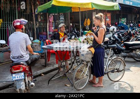 Ein weiblicher Reisender Kauft Street Food Von A Stall, Battambang, Kambodscha. Stockfoto