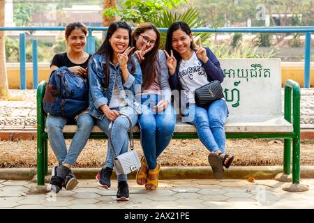 Eine Gruppe Junger kambodischer Frauen, Die Auf EINER Bank sitzen, Battambang, Kambodscha. Stockfoto