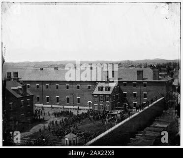 1865, 7. juli, Navy Yard, WASHINGTON, D.C., USA: Hinrichtung der Verschwörer: Gerüst im Einsatz und Menge im Hof, vom Dach des Arsenals aus gesehen. Die vier Verurteilten, Frau Mary Surratt (* um 1820; † 1865), Lewis Powell im Alter von 21 Jahren ( alias Lewis Payne oder Paine , 1844 - 1865 ), David E. Herold und George A. Atzerodt, der Tag des Aufhängens . Mary Surratt wird die erste Frau, die von der US-Bundesregierung hingerichtet wurde. Der Präsident der Vereinigten Staaten, ABRAHAM LINCOLN (* 1809; † 1865), starb am 15. April 1865 . Foto von Alexander GARDNER (* um 181-1882 in London). - Presidente della Repu Stockfoto