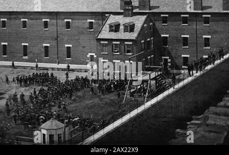 1865, 7. juli, Navy Yard, WASHINGTON, D.C., USA: Hinrichtung der Verschwörer: Gerüst im Einsatz und Menge im Hof, vom Dach des Arsenals aus gesehen. Die vier Verurteilten, Frau Mary Surratt (* um 1820; † 1865), Lewis Powell im Alter von 21 Jahren ( alias Lewis Payne oder Paine , 1844 - 1865 ), David E. Herold und George A. Atzerodt, der Tag des Aufhängens . Mary Surratt wird die erste Frau, die von der US-Bundesregierung hingerichtet wurde. Der Präsident der Vereinigten Staaten, ABRAHAM LINCOLN (* 1809; † 1865), starb am 15. April 1865 . Foto von Alexander GARDNER (* um 181-1882 in London). - Presidente della Repu Stockfoto