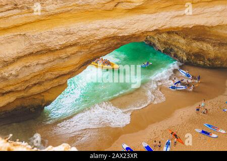 Benagil Höhle in Portugal, Carvoeiro Algarve, Lagos. Touristen, die auf Paddle-Boards für SUP, Kajak, Motorboote nach Praia de Benagil schwimmen. Benagil Cave t Stockfoto