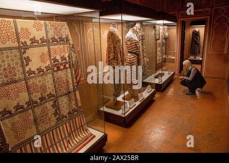 Indien, Rajasthan, Jaipur, Amber, Anokhi Museum of Hand Printing, Besucher in der Galerie, die Kleidung mit traditionellem ajrakh Block bedrucktem Text zeigt Stockfoto
