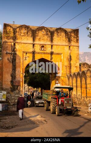 Indien, Rajasthan, Jaipur, Indrapuri, Gaitor Road, Traktor, der unter dem Samrat Gate in historischen Stadtmauern vorbeiführt Stockfoto