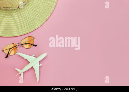Strandzusammensetzung im Sommer. Minimale, einfache flache Lage mit planaren Sonnenbrillen und Hut isoliert auf pastellrosa Hintergrund. Urlaub Reise Abenteuer Konzept. Kopierbereich in der Draufsicht Stockfoto