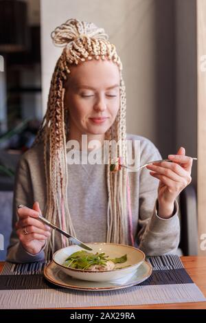 Eine junge attraktive Frau in einem Cafe mit einem Salat sitzen Stockfoto