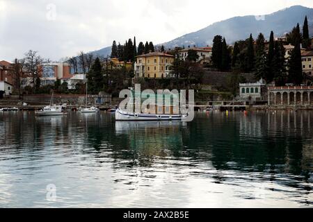 IKA, Kroatien, 9. Februar 2020. Blick von der Küste auf einen kleinen Hafen in einer kleinen kroatischen Stadt an der Küste namens Ika am bewölkten Wintertag Stockfoto
