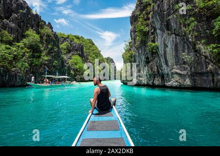 El Nido, Palawan, Philippinen, Reisende, die auf dem Bootsdeck sitzen und an einem sonnigen Tag die natürlichen Sehenswürdigkeiten rund um El Nido erkunden. Stockfoto