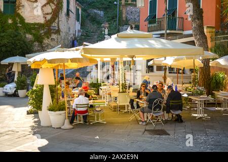 Touristen genießen eine Nachmittagsküree auf der Terrasse eines Restaurants in der Ferienstadt Portovenere, Italien Stockfoto