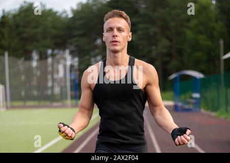 Ein Mann erwärmt sich vor dem Training im Stadion. Stockfoto