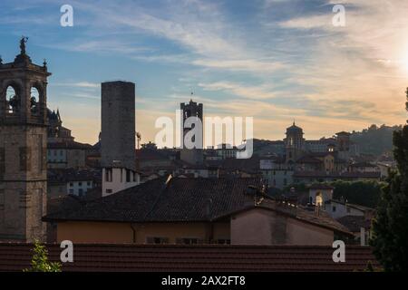 Bergamo Dächer durch Frühling Abendhimmel hintergrundiert. Top Dächer und historische Türme Landschaft hoto des mittelalterlichen Stadtzentrums in der Lombardei Region Italien. Stockfoto