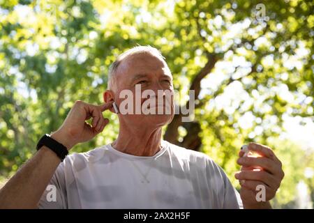 Jogger, der im Park Musik hört Stockfoto