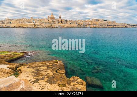 Schöner Blick auf Valletta, die Skyline der Altstadt von Malta, von Sliema Stadt auf der anderen Seite des Marsans Hafen während des Sonnenaufgangs Stockfoto