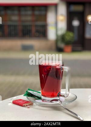 Ein Glas Kräuterfrüchtetee auf dem Tisch im Restaurant im Freien. Gesunde Ernährung, Entspannung, Entschlackung und fünf Oklocken-Teekonzept Stockfoto